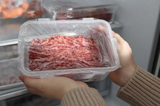 Can you cook mince from Frozen? A woman taking out frozen mince meat from the freezer.