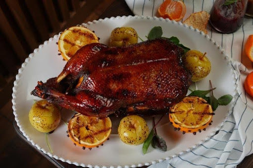 Whole roasted duck with oranges and potatoes.
